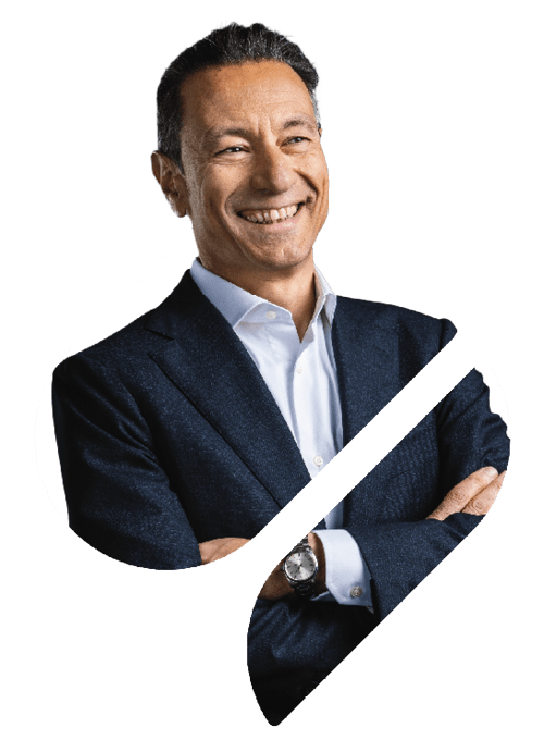 A professional portrait of Steam Thermal Solutions Managing Director Maurizio Preziosa in the Spirax Group S shape. He is standing with his arms crossed and smiling, looking out to a distant point to the right