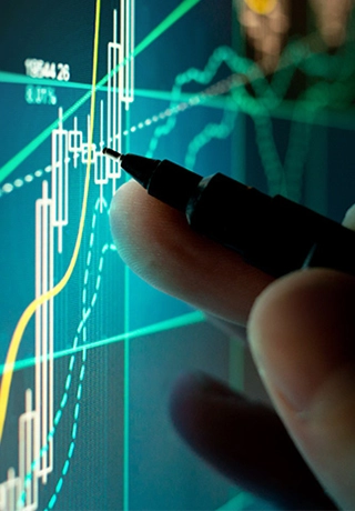 A hand with a pen is hovering over a digital line graph