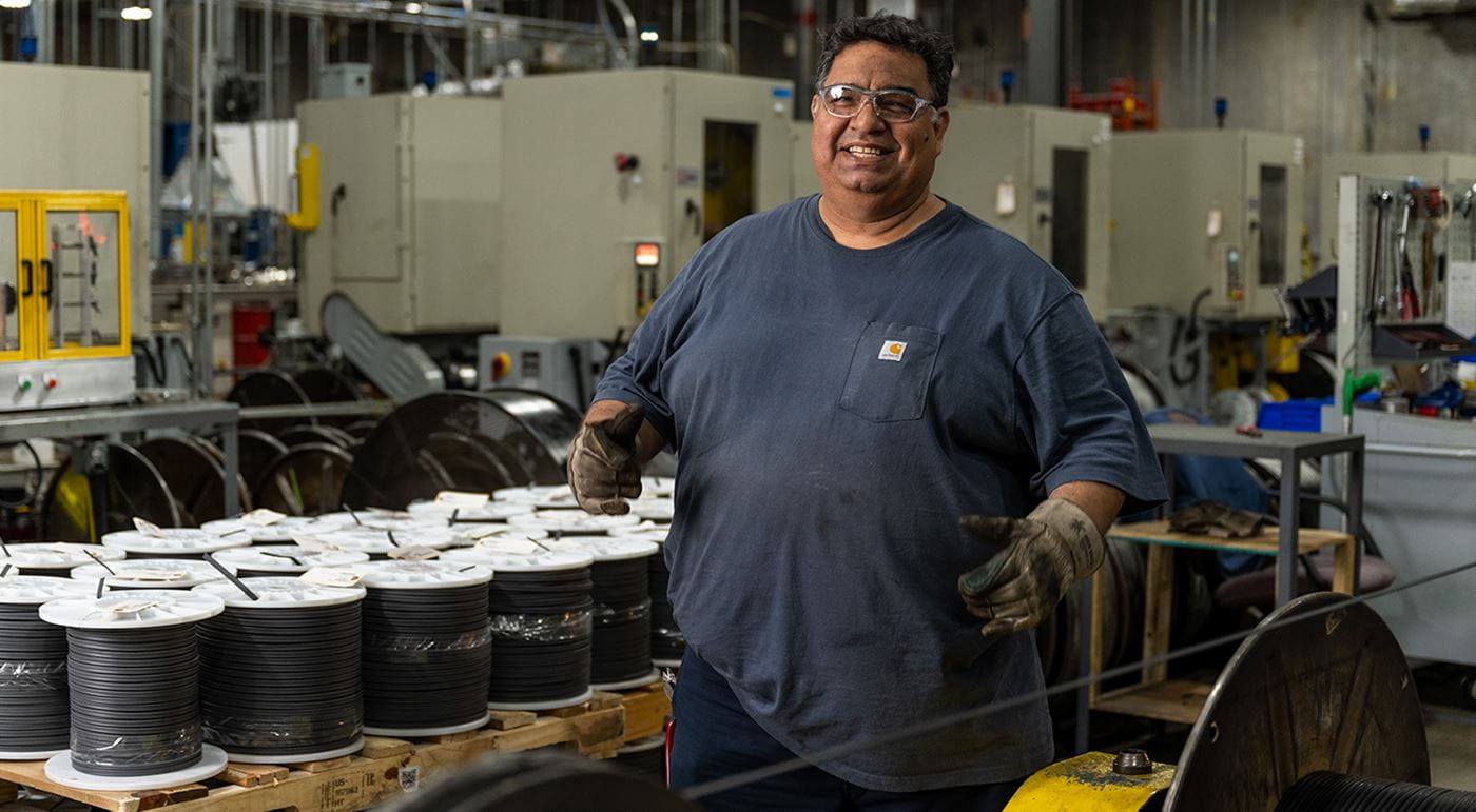 A male Electric Thermal Solutions colleague in the manufacturing space smiling at the camera