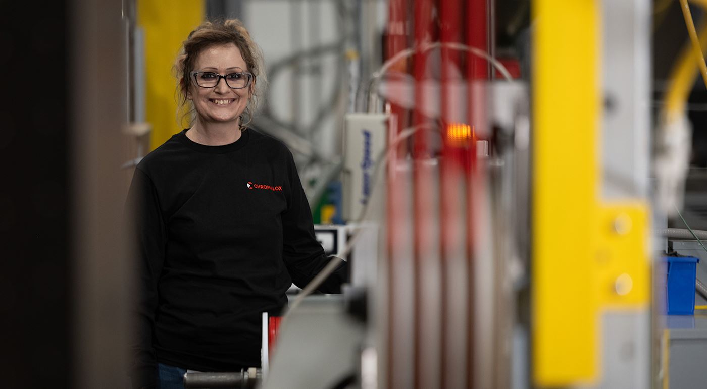 A female Electric Thermal Solutions colleague in the manufacturing space smiling at the camera