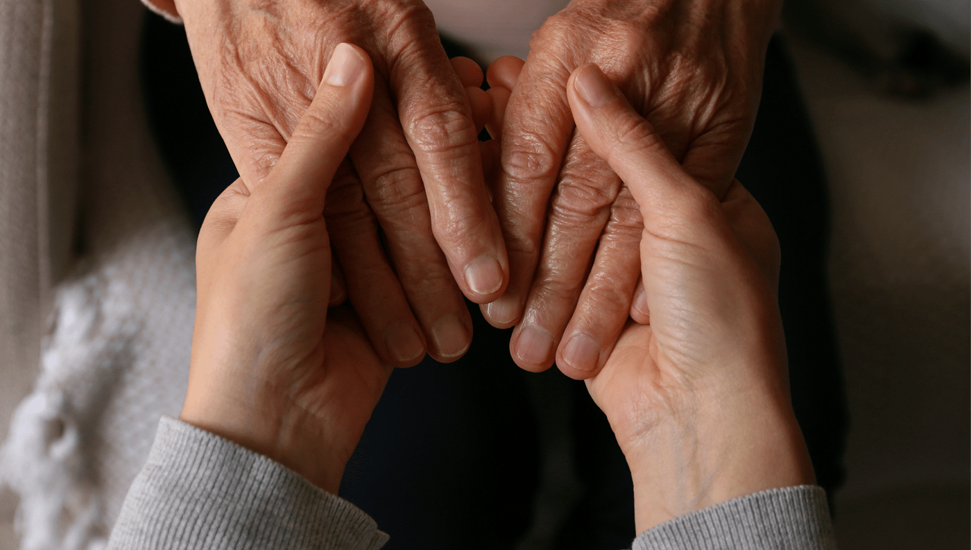 A young person and an older person holding each other's hands