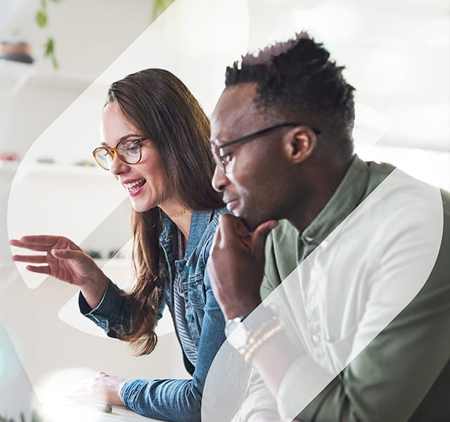 A man and a woman in an office sitting side by side in discussion