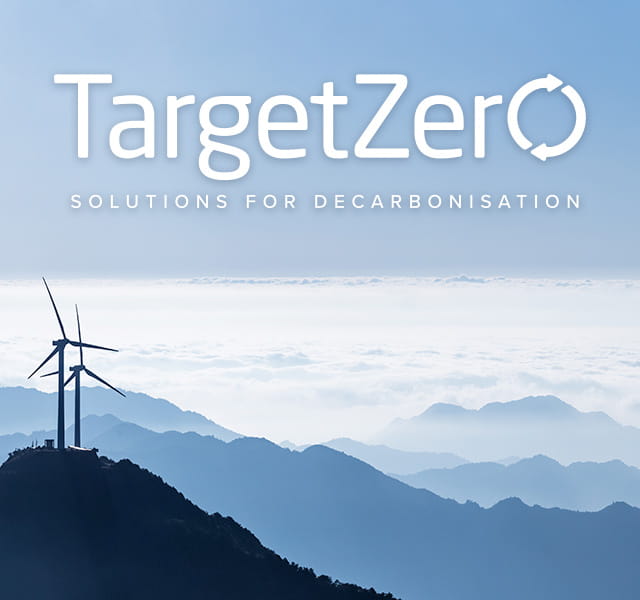 Two wind turbines in shadow sit at the top of a hill. There is a bigger hill behind them and clouds above. In the cloud section, the Target Zero logo is overlaid